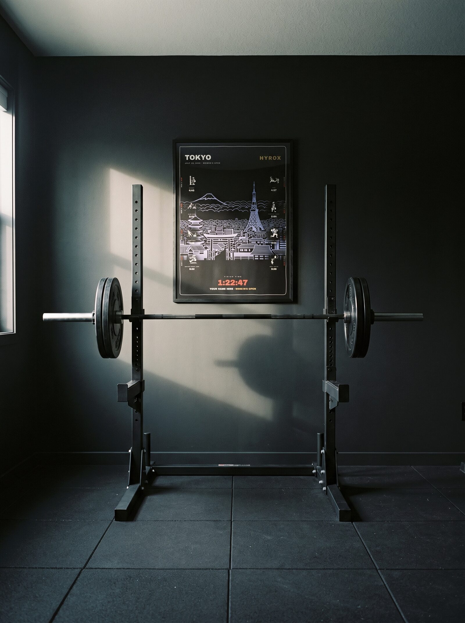 The Noir Tokyo women's edition in a black frame behind a squat rack